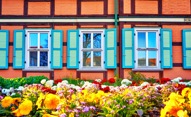 Colorful spring flowers in a front garden of a half-timbered house.
