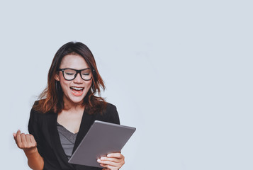 Fototapeta premium Asian woman smiled in a happy mood as she stared at her iPad.