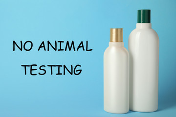Bottles of cosmetic products and text NO ANIMAL TESTING on light blue background
