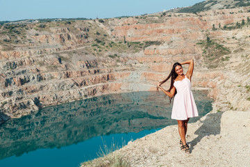 Fototapeta na wymiar Beautiful woman in dress looks at the view of a mountain lake