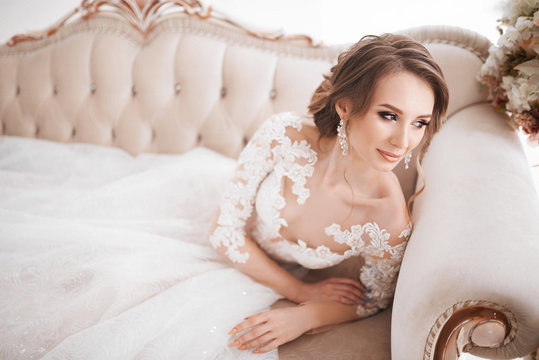 A beautiful girl is standing in a wedding dress. Photoshoot in white. Stylish photo shoot of the bride