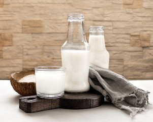 Coconut milk in glass bottles on a light background.