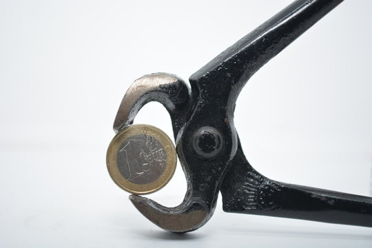 moneta di un euro nella tenaglia concetto di una stretta alla economia 