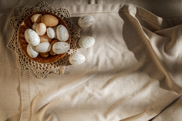 Fototapeta na wymiar Festive eggs on a wooden table covered with a tablecloth in the morning