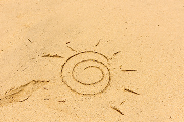Image of sun drawing on sand. Sandy background.