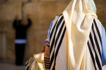 Orthodox Jew praying at the Western Wall, wearing the tallit prayer shawl and tefillin