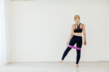 Obraz premium Beautiful athlete develops muscles with fitness gum