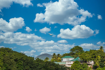 Fototapeta na wymiar A twin propeller plane taking off over a tropical paradise