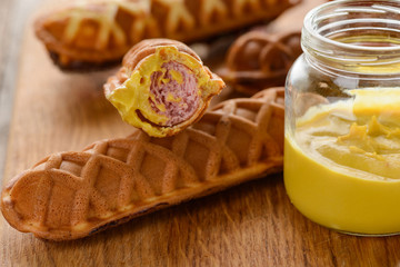 Appetizing corn dogs with mustard dip, close up