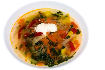 Vegetable soup with sour cream on a white background.