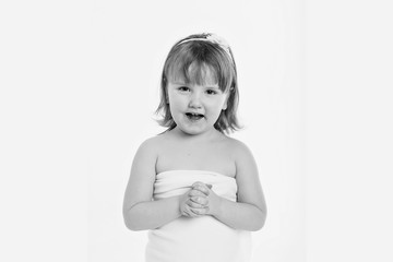 a little girl grimaces against a white background. The child is up to something. Concept of emotions , facial expressions, childhood, sincerity