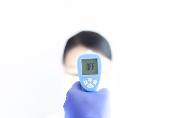 Doctor check woman body temperature using infrared thermometer for virus symptom