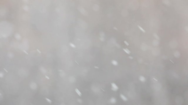 Snowfall in a city. Simple scene - falling snowflakes on a cityscape background.