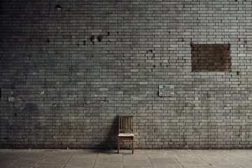 Lonely chair against bricks wall