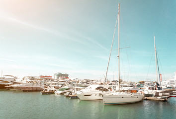 Fototapeta na wymiar SOCHI, RUSSIA - November 4, 2019: Yachts and boats in seaport of Sochi, Russia. Seascape at the port in soft sunny rays, editorial photo