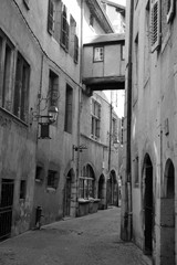 Chambéry, France - August 11th 2017 : narrow street in the old town, with a covered passage that connects two buildings together which looks like a small hanging house.