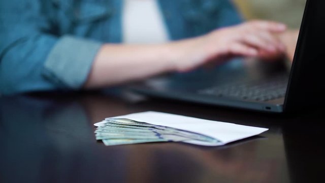 Crop office worker receiving salary in cash money