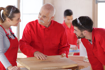 smiling students and teacher in carpentry class
