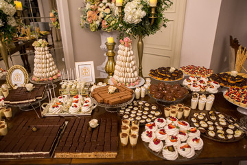 Delicious candy bar with macaroons, cupcakes and other sweets
