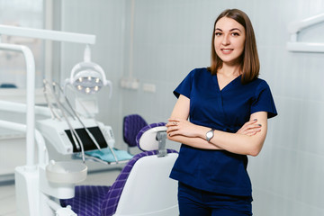 Portrait of a smiling female dentist in the office of a modern dental clinic.