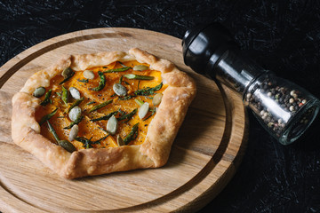 Gallet with pumpkin, asparagus and pumpkin seeds on a black background. Seasonal dishes. Diet Baking