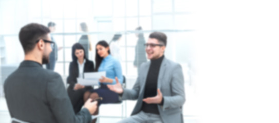 young businessman discussing with a colleague his ideas. Background for text with people in blur