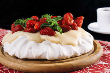 Dessert Anna Pavlova with strawberries on a black background