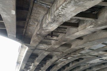 old weathered concrete beam under a bridge