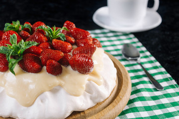 Dessert Anna Pavlova with strawberries on a black background