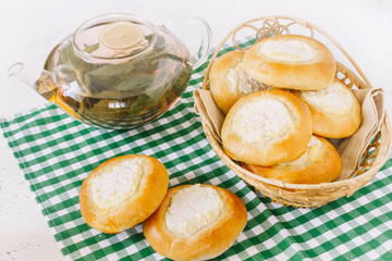 Bun with cottage cheese and tea with mint and berries. Cheesecakes. Homemade baking