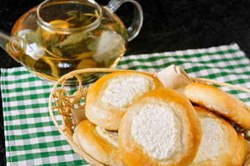 Bun with cottage cheese and tea with mint and berries. Cheesecakes. Homemade baking