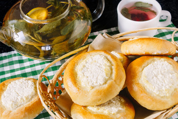 Bun with cottage cheese and tea with mint and berries. Cheesecakes. Homemade baking