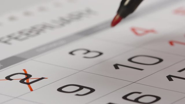 CLOSE UP: Crossing out a numbers in a paper calendar