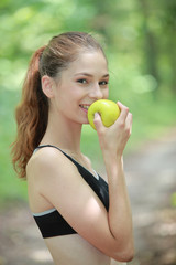 Jeune femme sportive mangeant une pomme