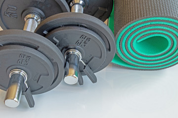 a set of dumbbells and a mat for sports