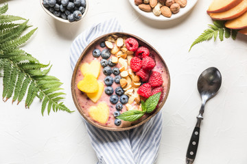 Healthy breakfast banana and blueberry smoothie decorated with fruits in coconut bowl.