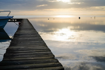 Fototapeta na wymiar Biscarrosse lake sunset wooden ponton on water for boat fishing