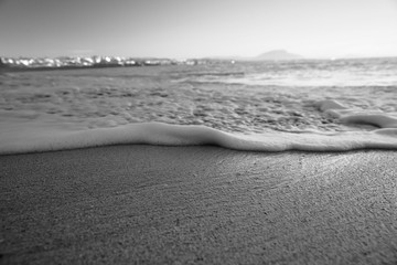 Fototapeta na wymiar Wave On Sandy Beach. Background. Splash of waves on the sandy beach. foam, surf, waves.