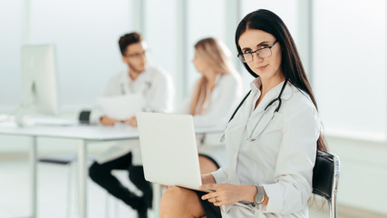 therapist with a laptop sitting in the hospital office