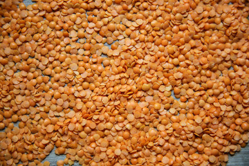Red raw lentils on wooden background