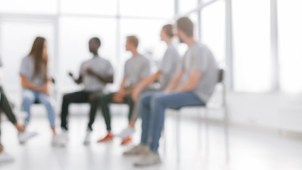 background image of a group of young people at a meeting in a c
