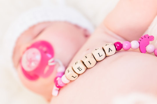 Baby Girl Named Leila Sleeping and Wearing a Wooden Pacifier Chain