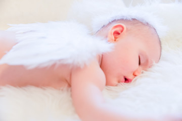 Baby Peacefully Sleeping whilst Wearing Angel Wings and Halo