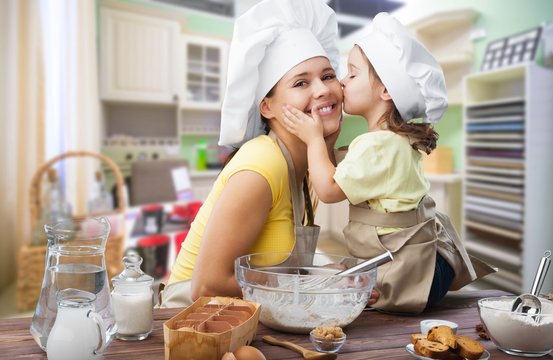 Happy mother and child cooking on kitchen interior