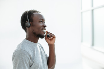 side view. young man with headset talking into microphone