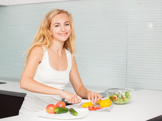 Obraz na płótnie Canvas Young woman preparing vegetable salad