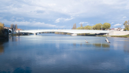 Obraz premium pont sur fleuve rejoignant deux rives dont l'une est civilisée