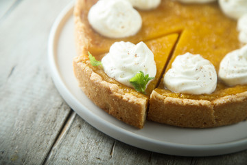 Fototapeta na wymiar Homemade pumpkin pie with whipped cream