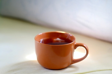 Cup of tea on a bed. Selective focus.