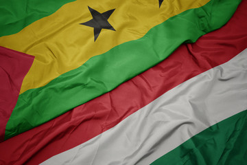 waving colorful flag of hungary and national flag of sao tome and principe .